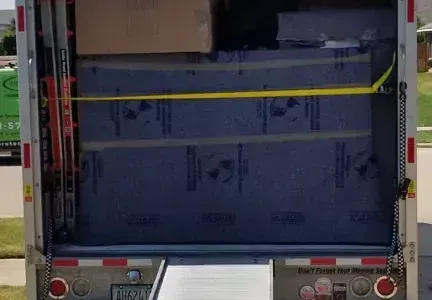 The back of a moving truck with boxes on it.