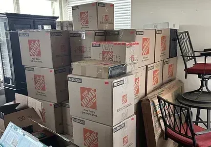 A bunch of moving boxes are stacked on top of each other in a living room.