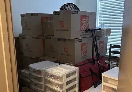 A room filled with boxes , drawers , and a red bag.