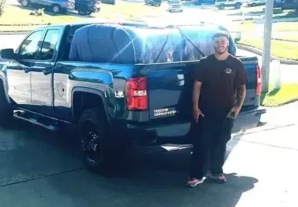 A man is standing in front of a truck.
