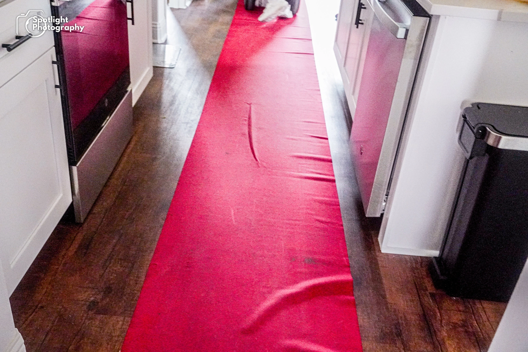 A red carpet is laying on the floor in a kitchen.