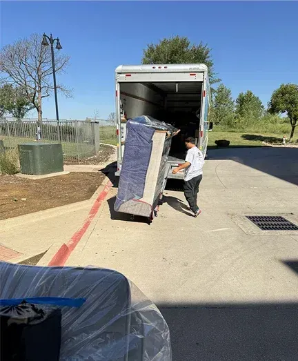 A man is loading a mattress into a moving truck.