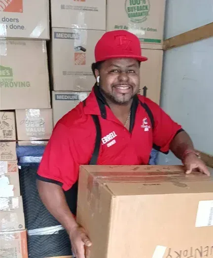 A man in a red shirt is holding a box that says kentucky