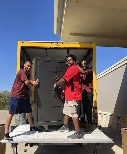 A group of men are loading a safe into a truck.
