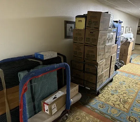 A room filled with boxes and a cart with boxes on it