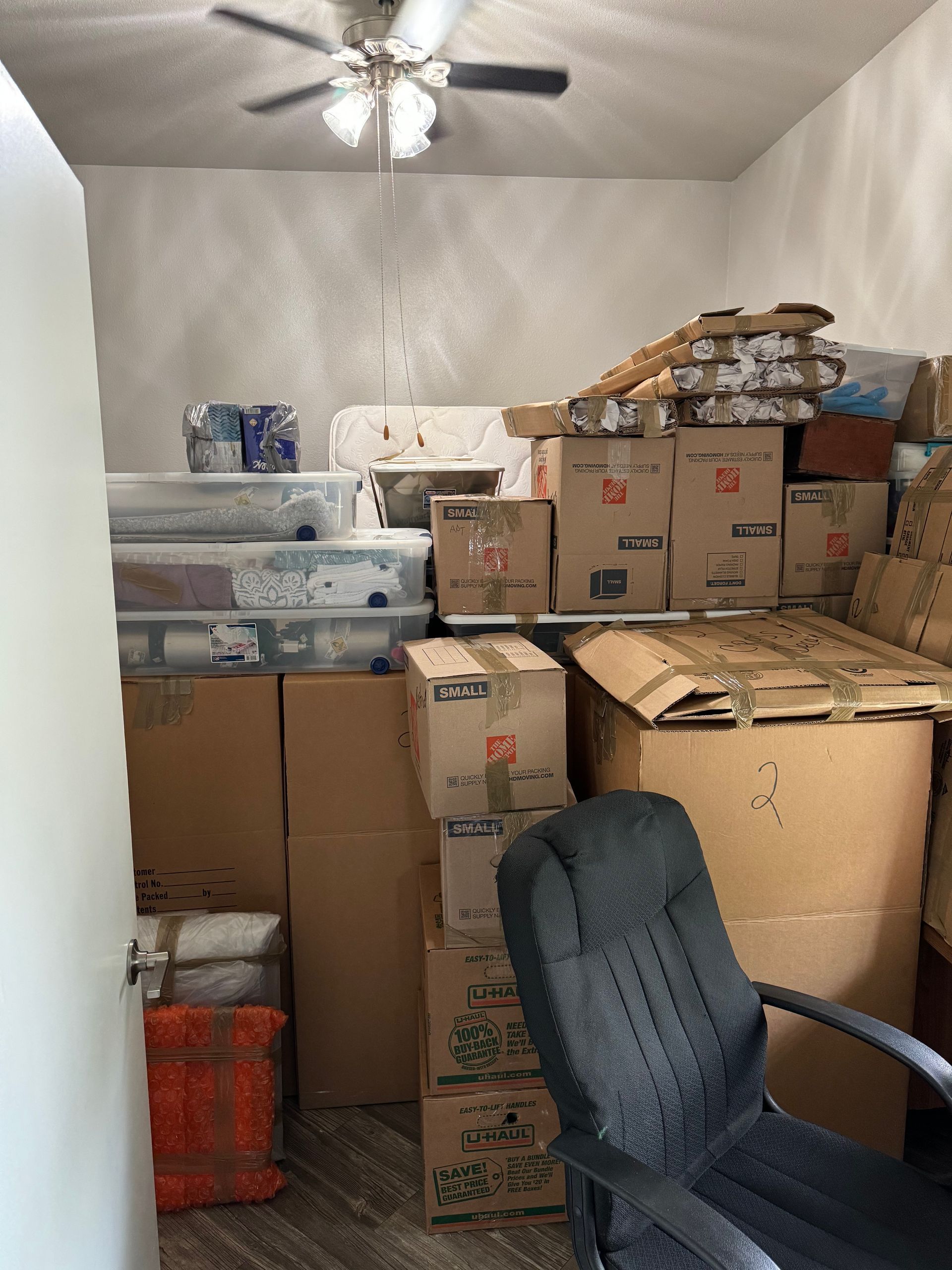 Two men are carrying a large piece of furniture on a dolly