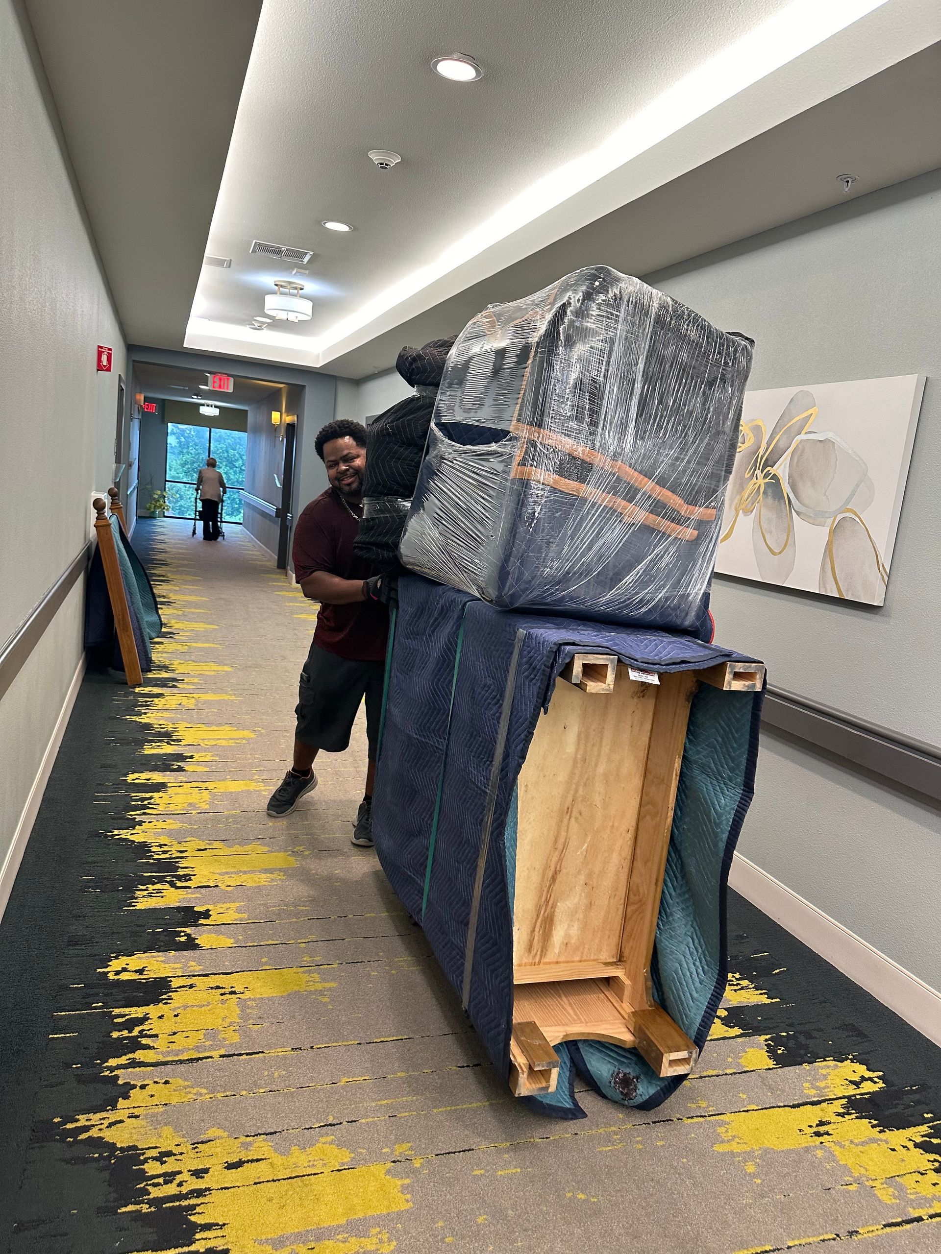 A man in a red shirt is pushing a suitcase on a ramp