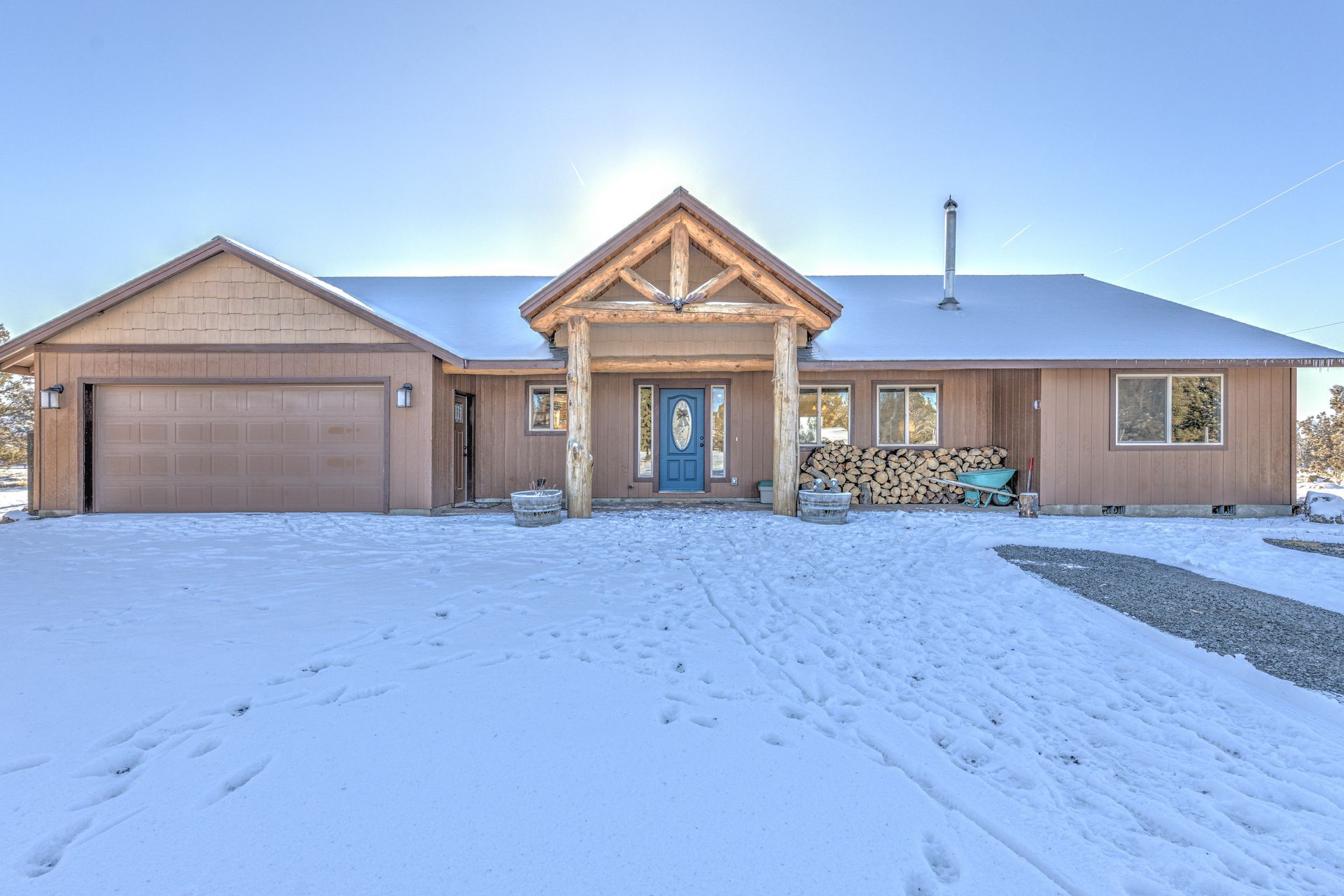 A large house with a blue door is covered in snow.