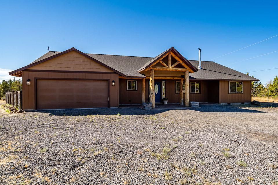A large brown house with a garage and a porch.