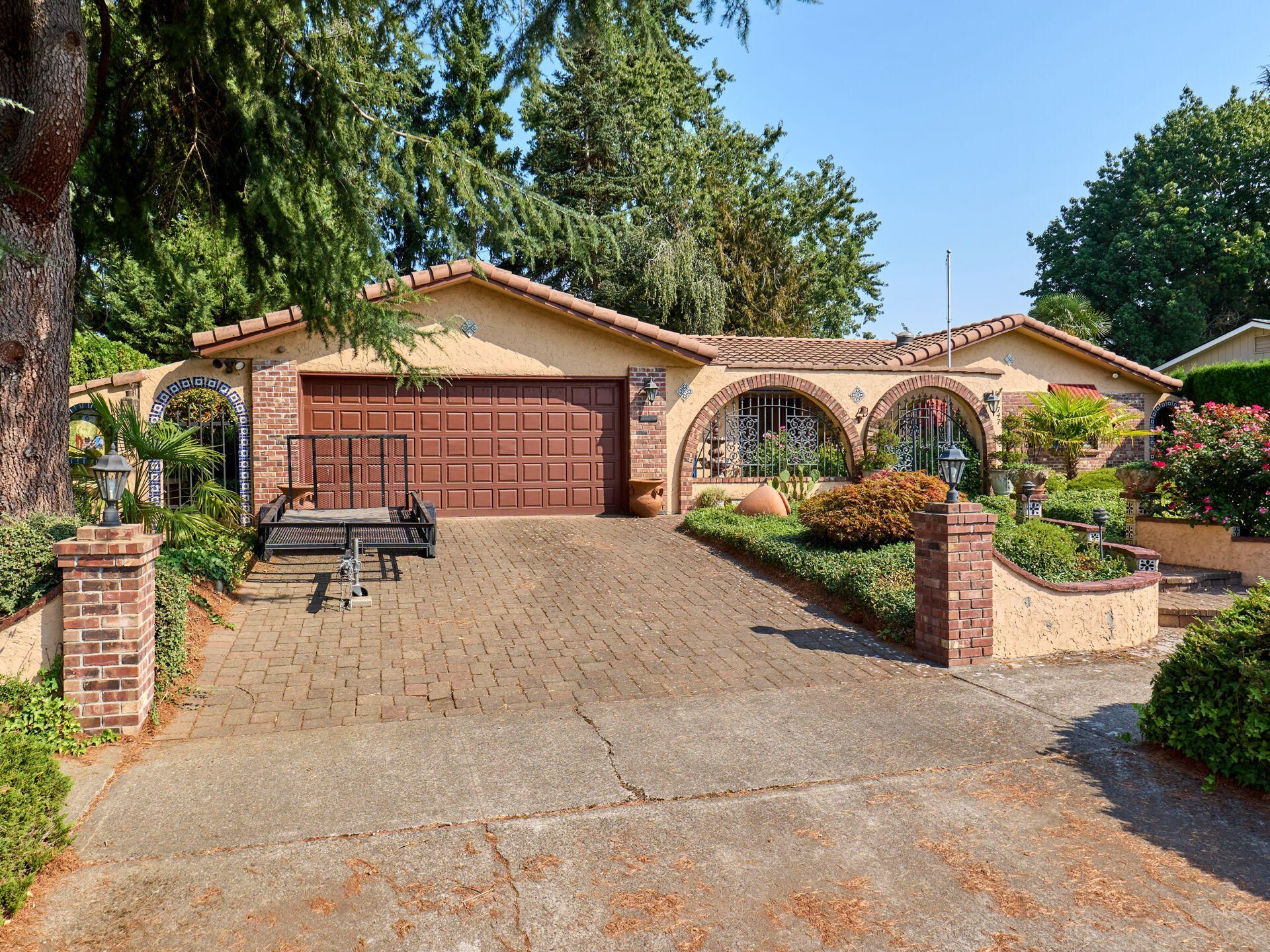 A house with a large garage and a picnic table in front of it