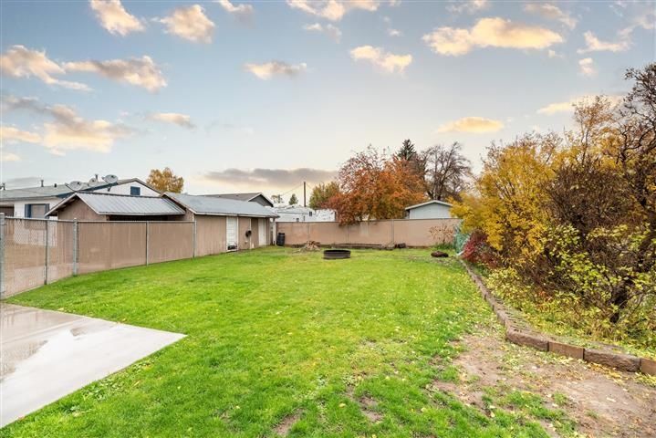 A backyard with a fence and a lot of grass