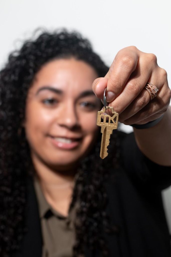 A man and a woman are posing for a picture while the woman is holding a pair of keys.