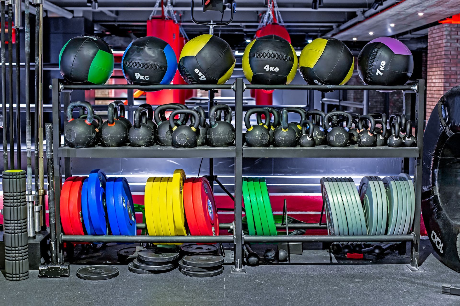 Gym equipment store display with kettlebells, medicine balls, and colorful weight plates. Gym equipment store display with kettlebells, medicine balls, and colorful weight plates.