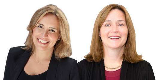 Two smiling professionals in dark blazers against a white background