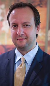 A man in a suit and tie is smiling for the camera.