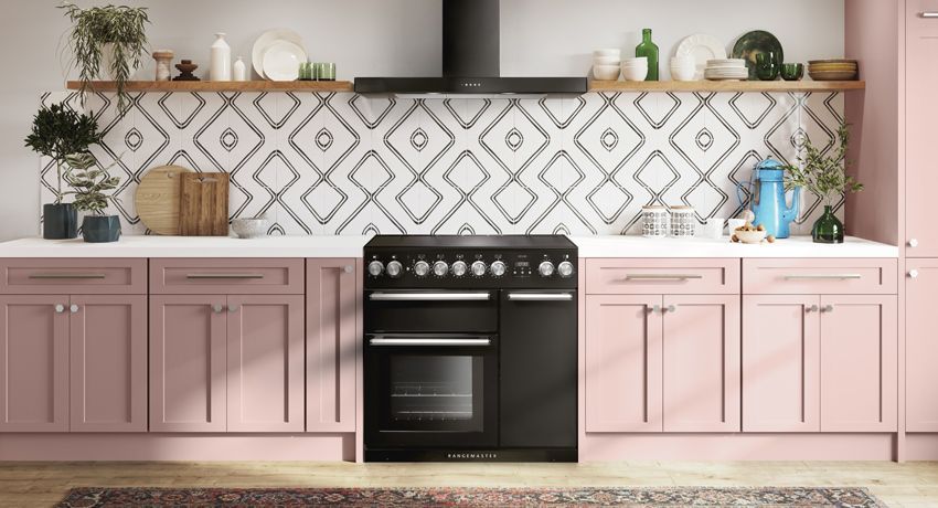 A kitchen with pink cabinets and a black stove.