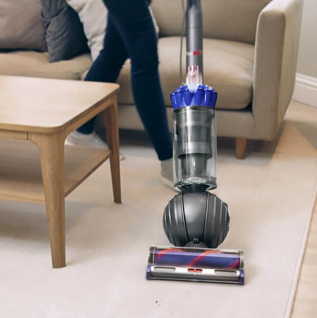 A person is using a vacuum cleaner in a living room