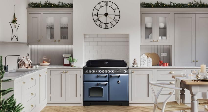 A kitchen with a blue stove and a clock on the wall.