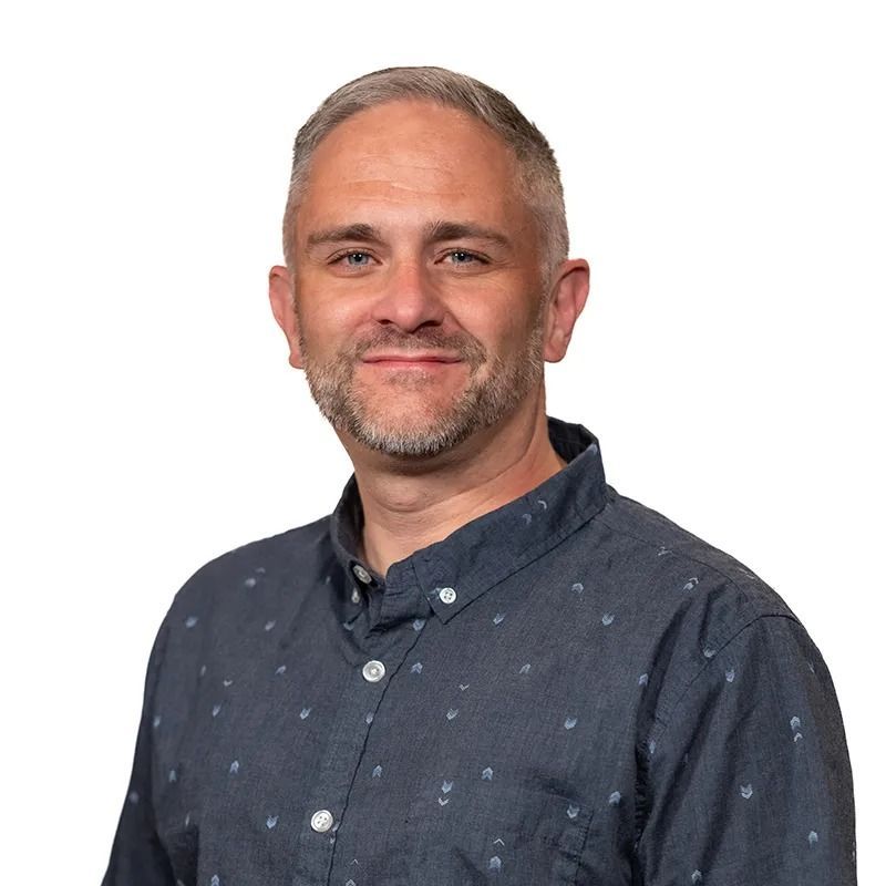 Cartoon of a man in a suit holding a tablet, text 