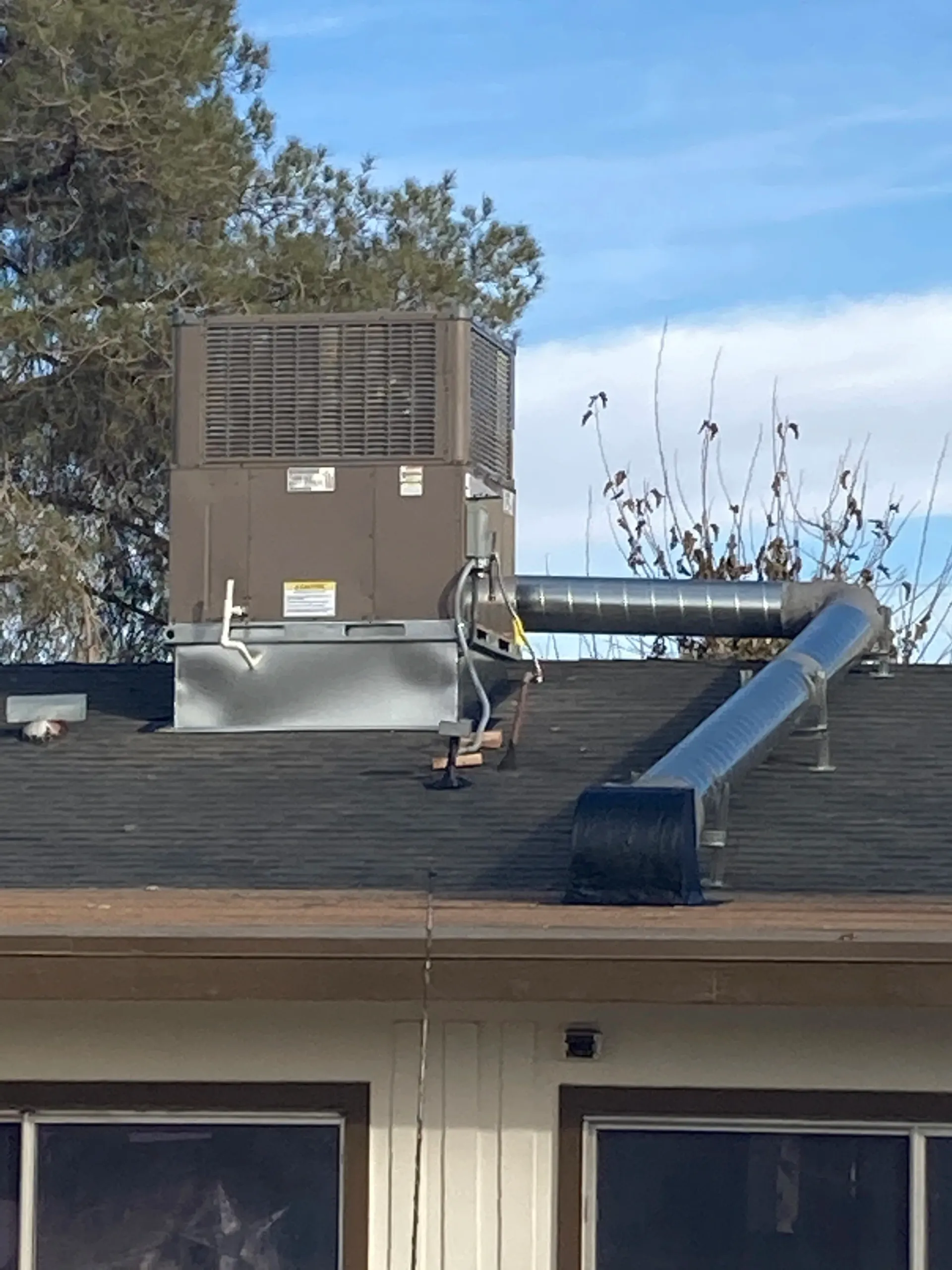 HVAC unit in an attic, with ductwork and PVC pipe visible.