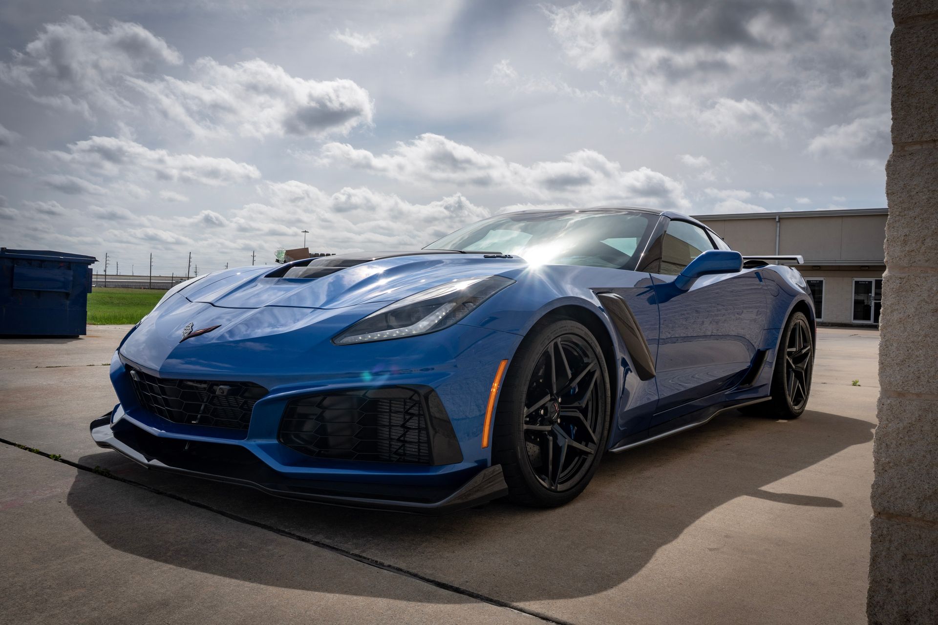 Blue Chevrolet Corvette Z06 sports car parked outside on a sunny day.