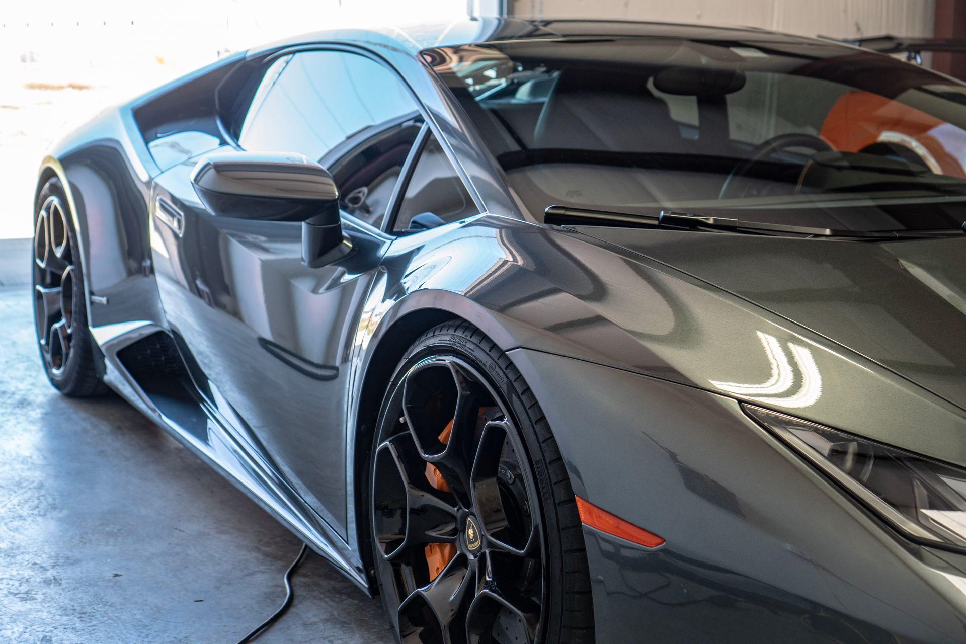 Gray Lamborghini sports car parked in a garage.