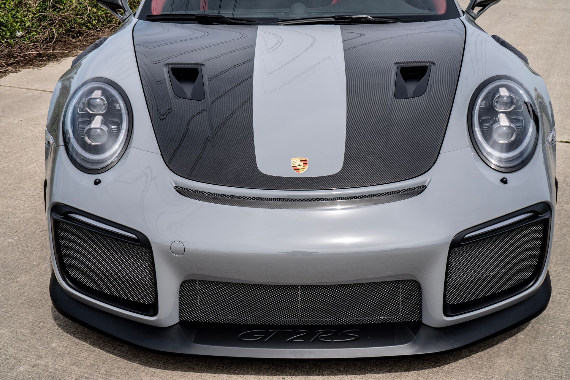 Gray Porsche 911 GT2 RS with black hood stripe, front view.
