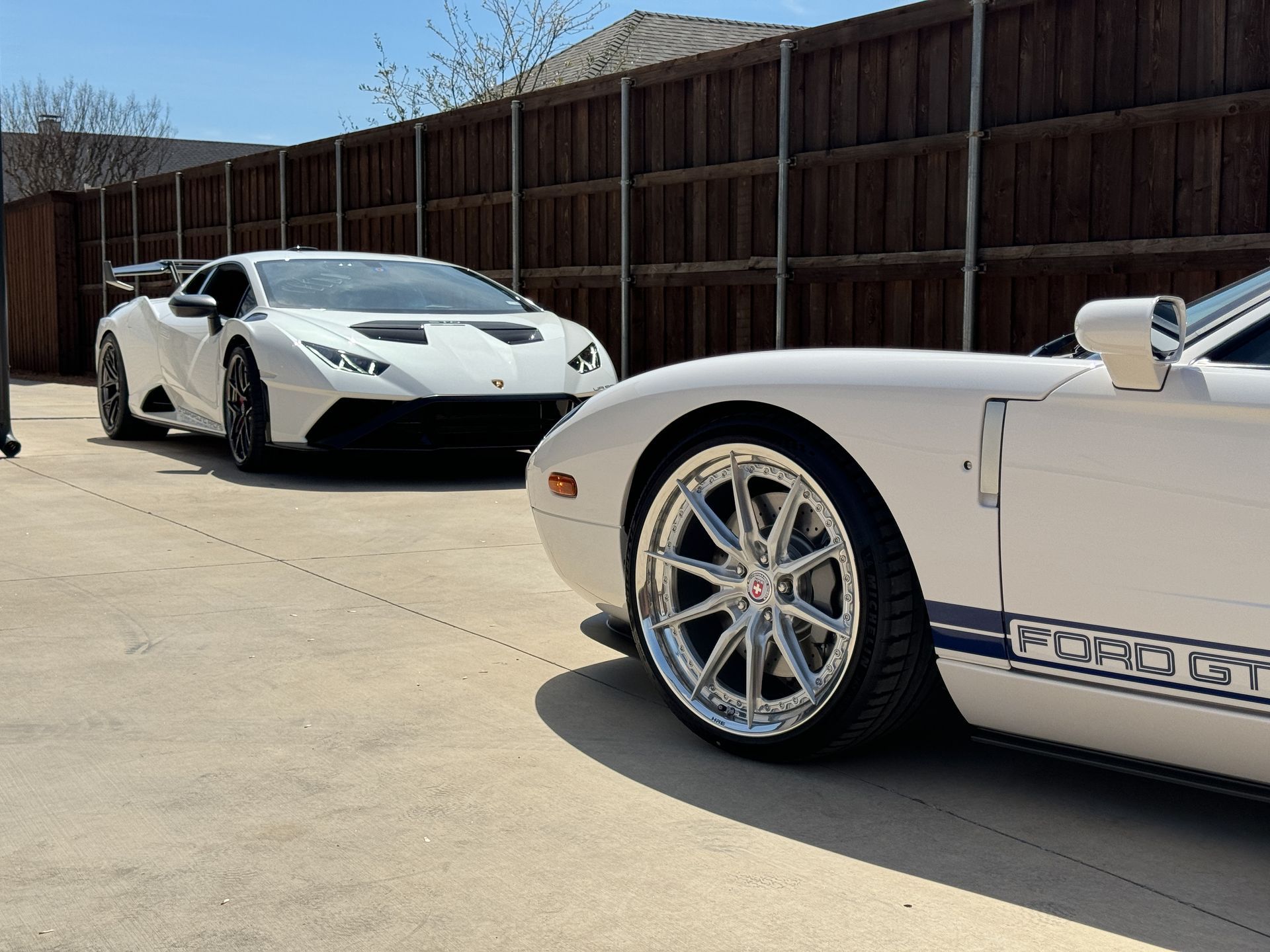 White Lamborghini and Ford GT parked next to each other on a sunny day.