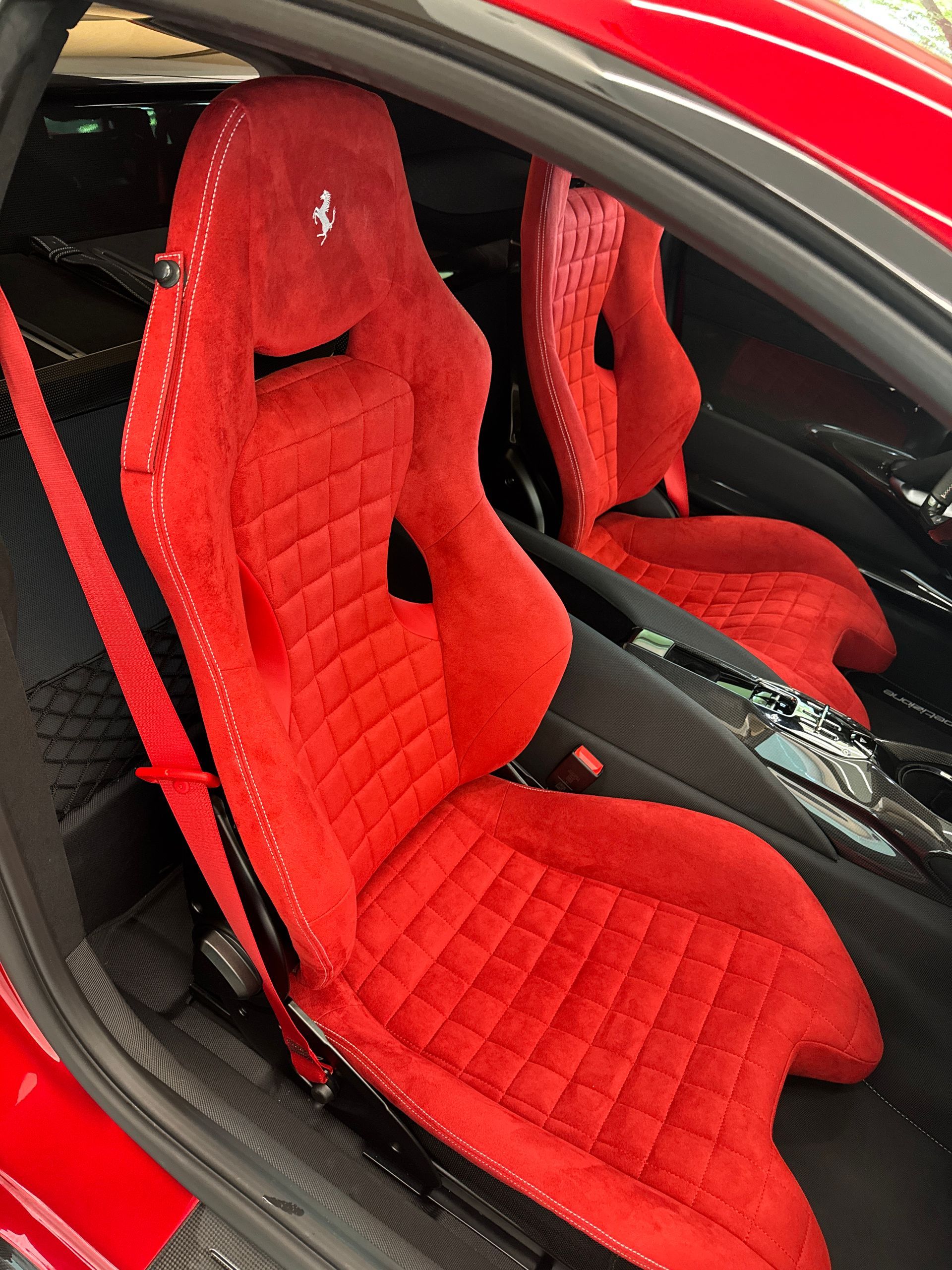 Red Ferrari car seats with diamond stitching.