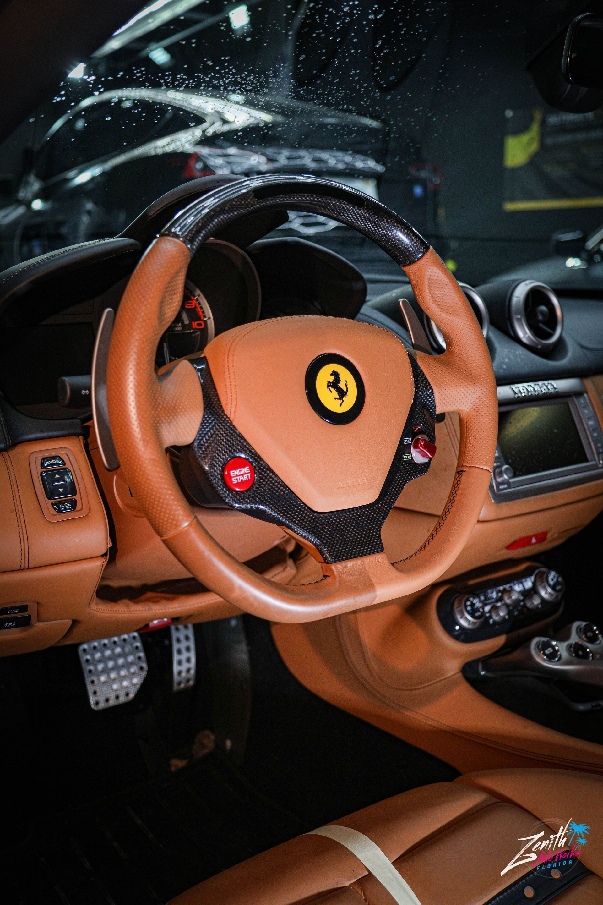 Tan Ferrari interior with carbon fiber and leather steering wheel.
