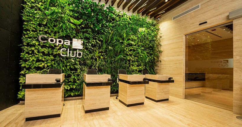 Un lobby con una pared verde y un cartel que dice copa club.