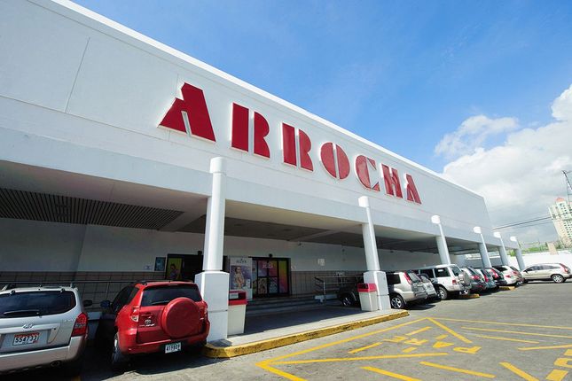 Una fila de autos están estacionados frente a una tienda llamada arrocha.