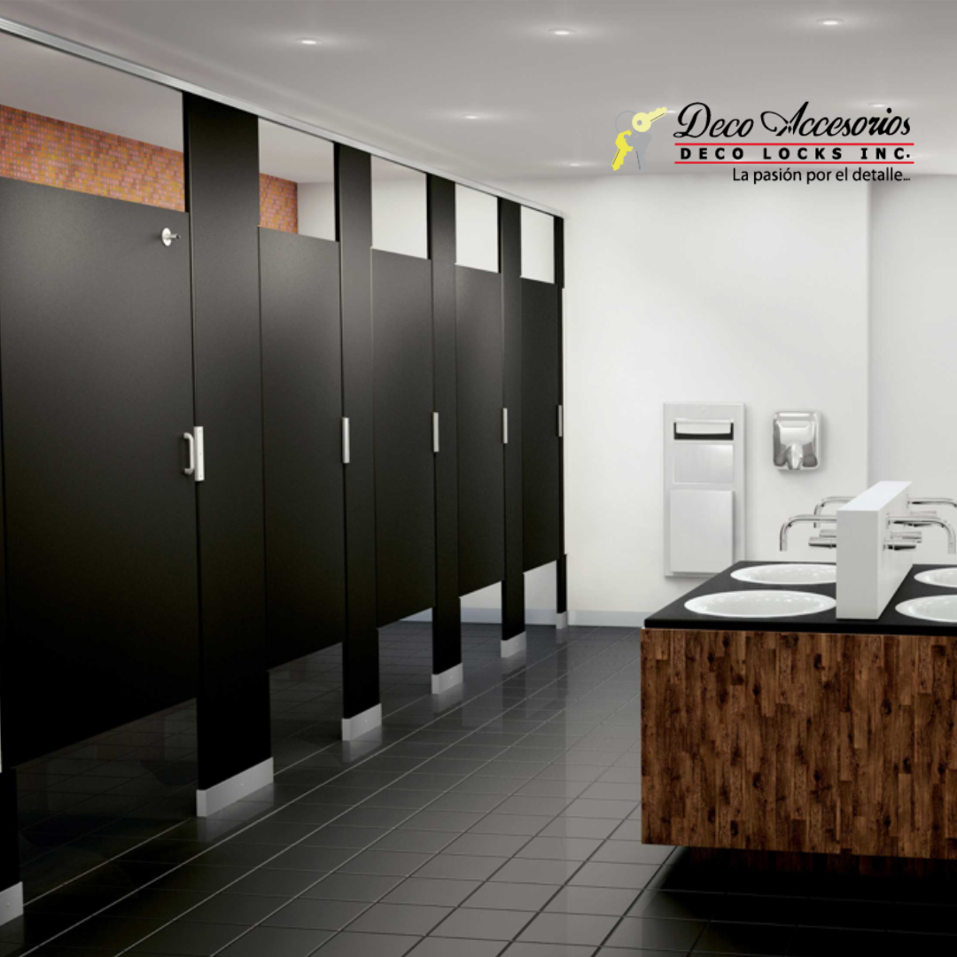 Baño público con cubículos negros, mueble lavabo marrón y piso de baldosas grises.