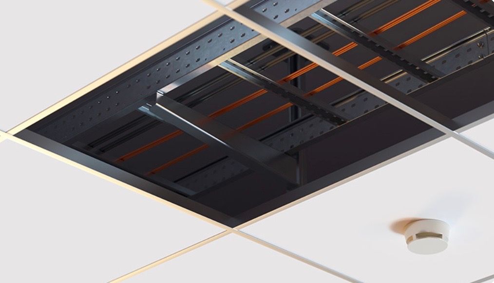 View of a black, open ceiling panel with structural beams and wires, set in a white ceiling grid, with a smoke detector.