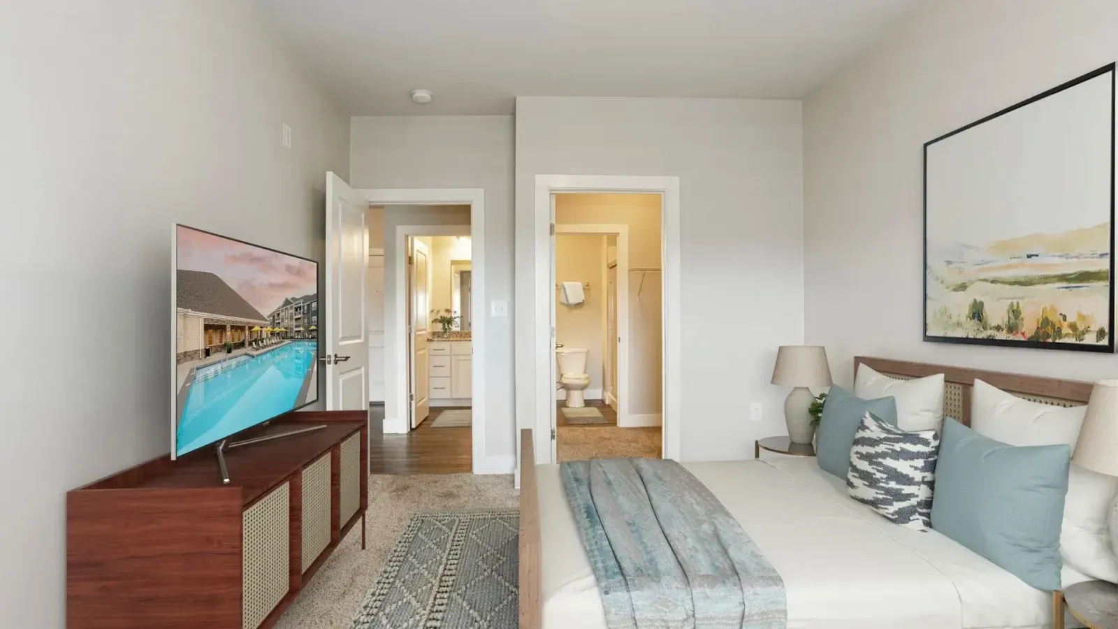 A bedroom with a large bed and a flat screen tv.