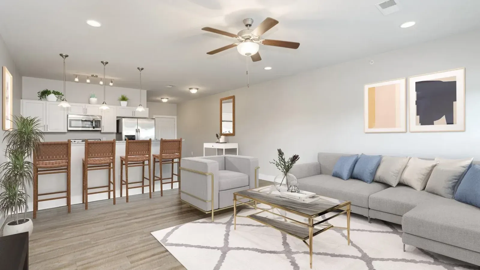 A living room with a couch , chair , coffee table and ceiling fan.