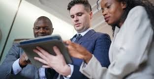 Um grupo de empresários está olhando para um tablet.