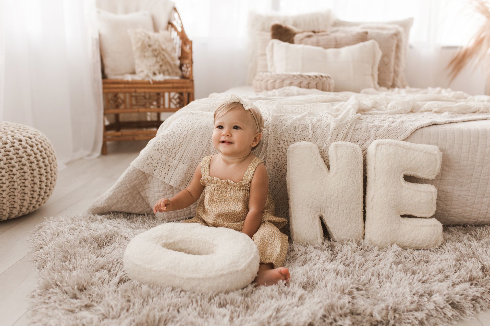A newborn baby is laying on his stomach on a white blanket.