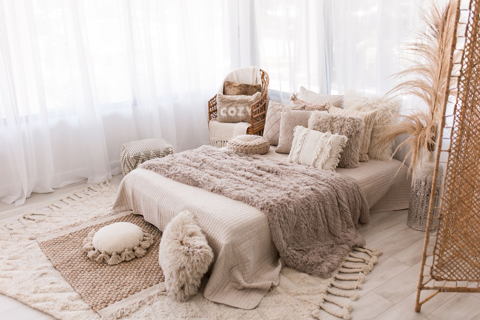 A baby is sitting in a small bed and smiling.