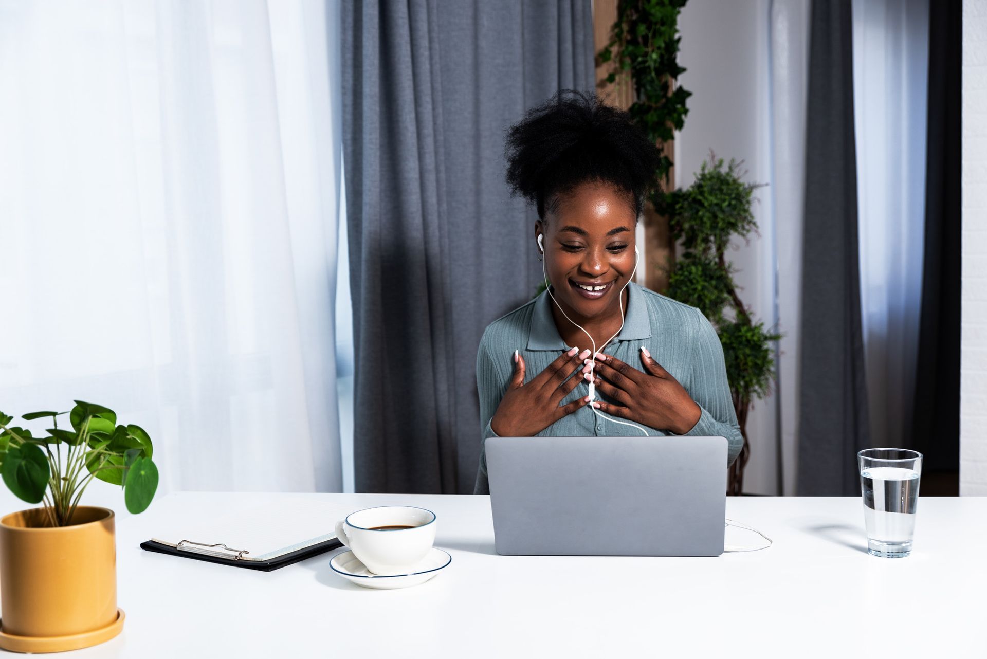 A woman is sitting at a desk using a laptop computer.