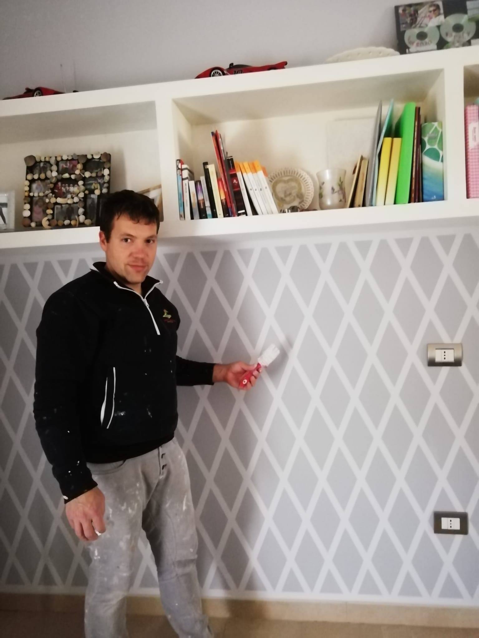 artigiano e titolare della ditta mentre dipinge una parete