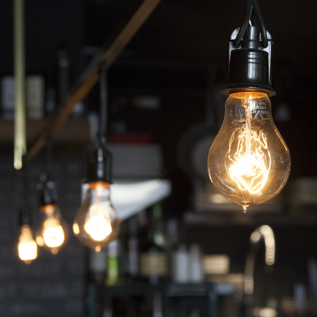 A row of light bulbs hanging from the ceiling in a dark room