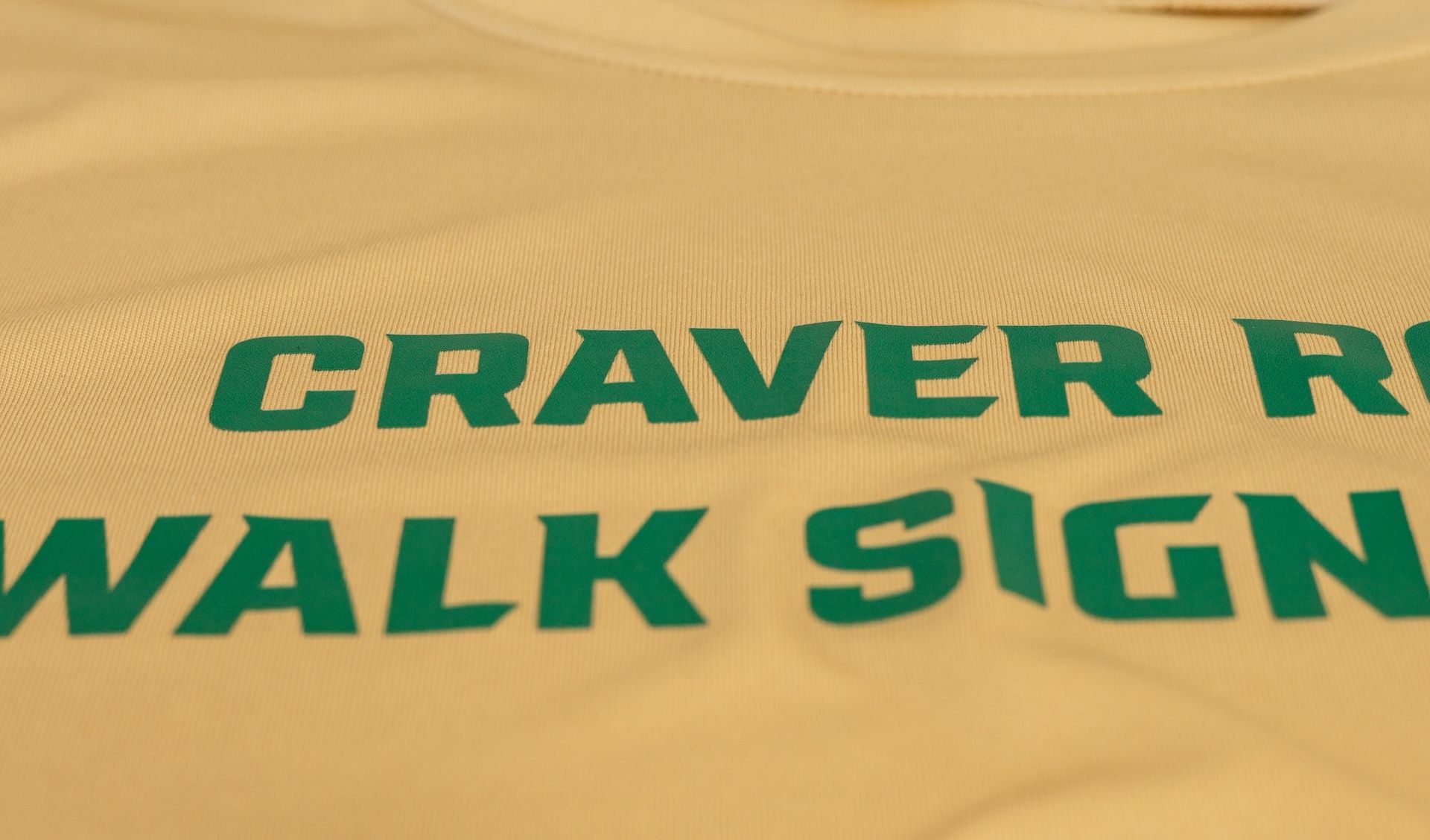 Green text on a beige fabric: 