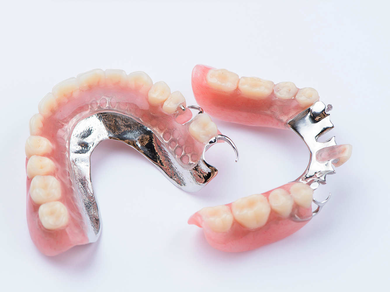 a pair of dentures with metal framework on two different partial dentures