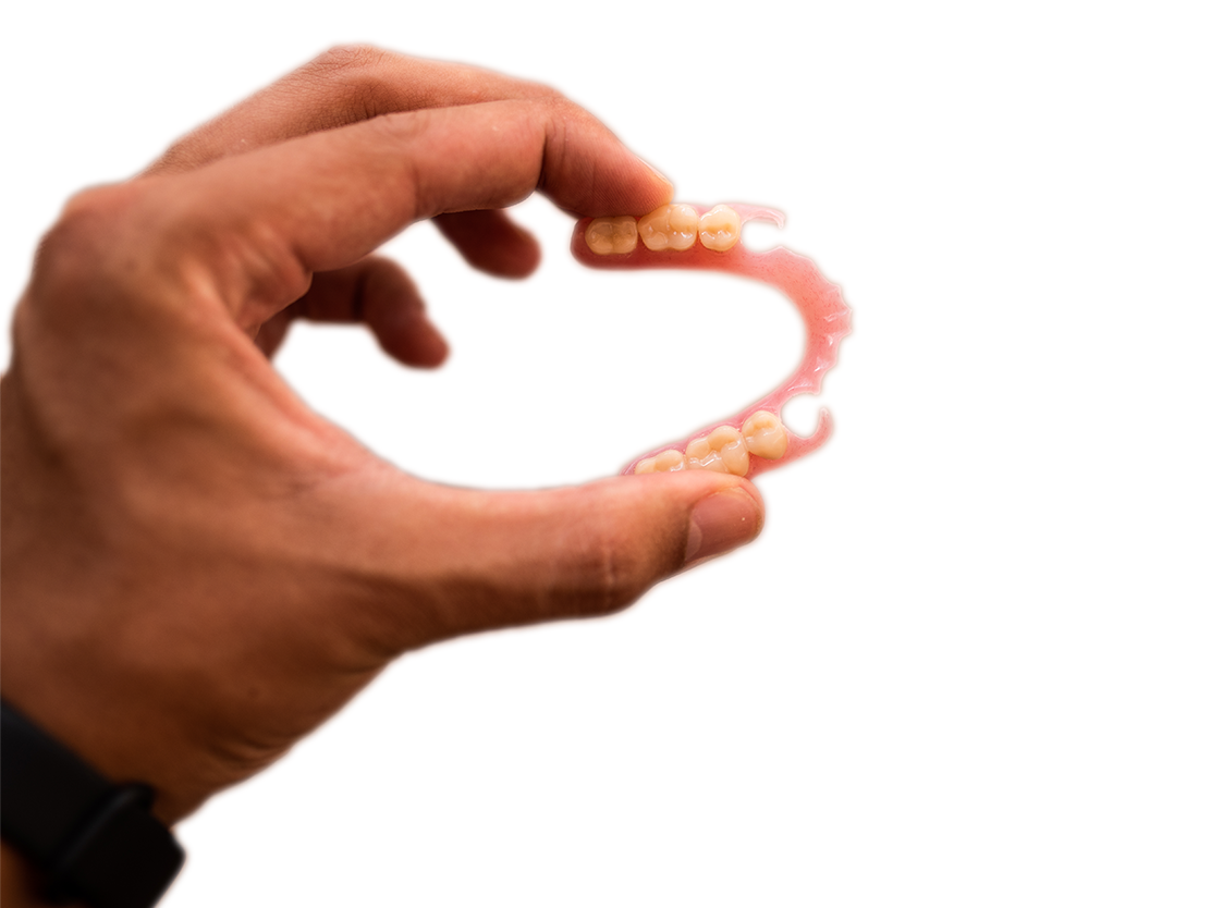 hand holding a partial denture showing the bend and flexibility in the dentures