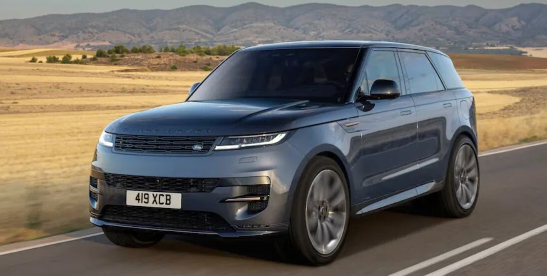 Blue Range Rover Sport SUV on a road with a desert backdrop.