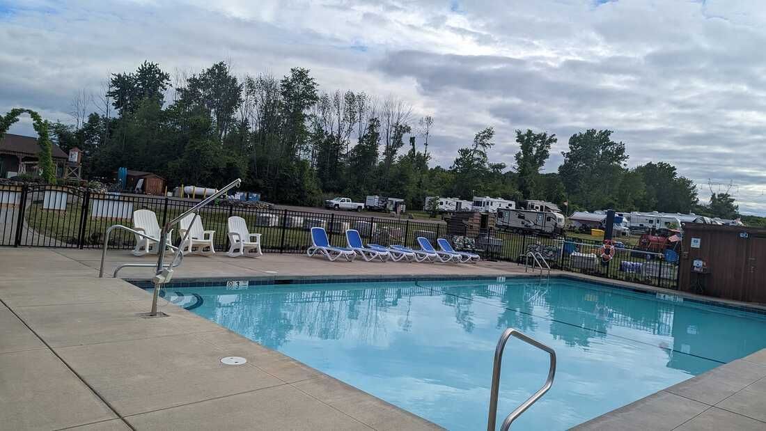 A large swimming pool with a lot of chairs around it.