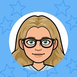 A woman in a white shirt is sitting at a table with a notebook.