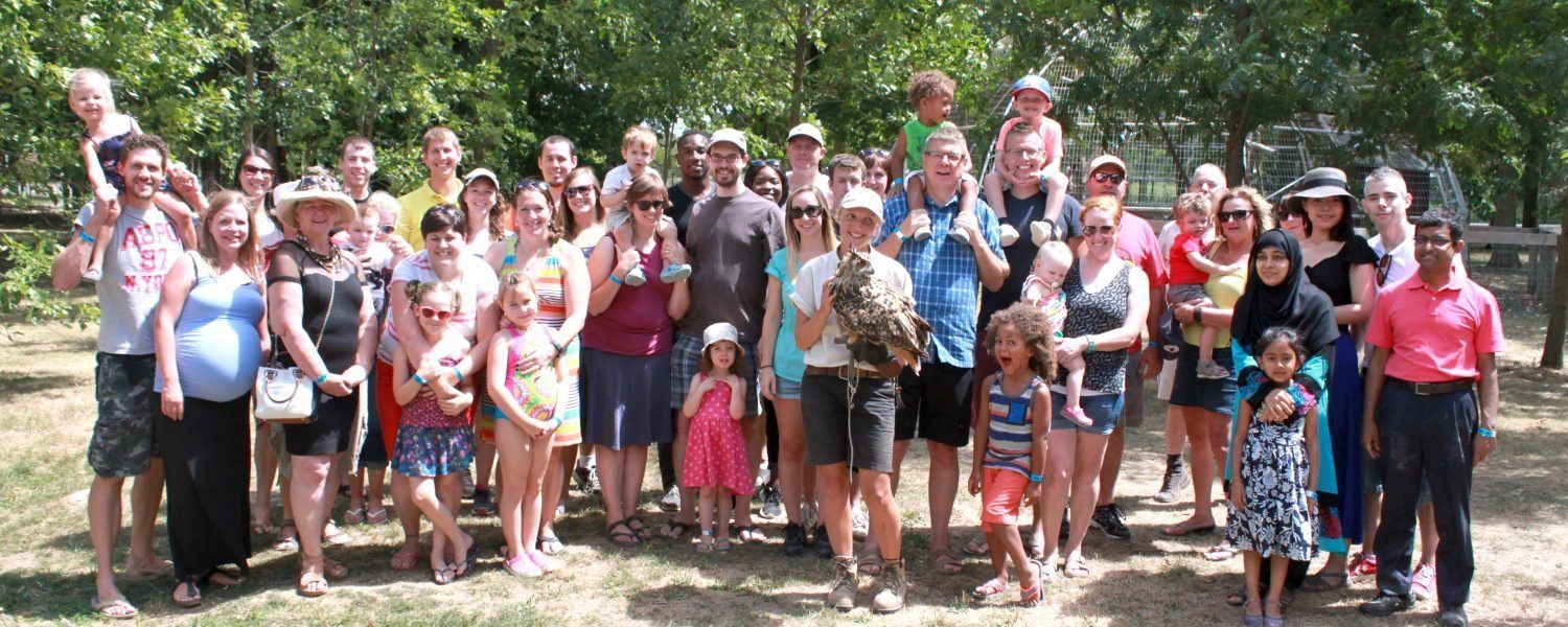 a large group of people are posing for a picture in a park during an educational zoo tour niagara