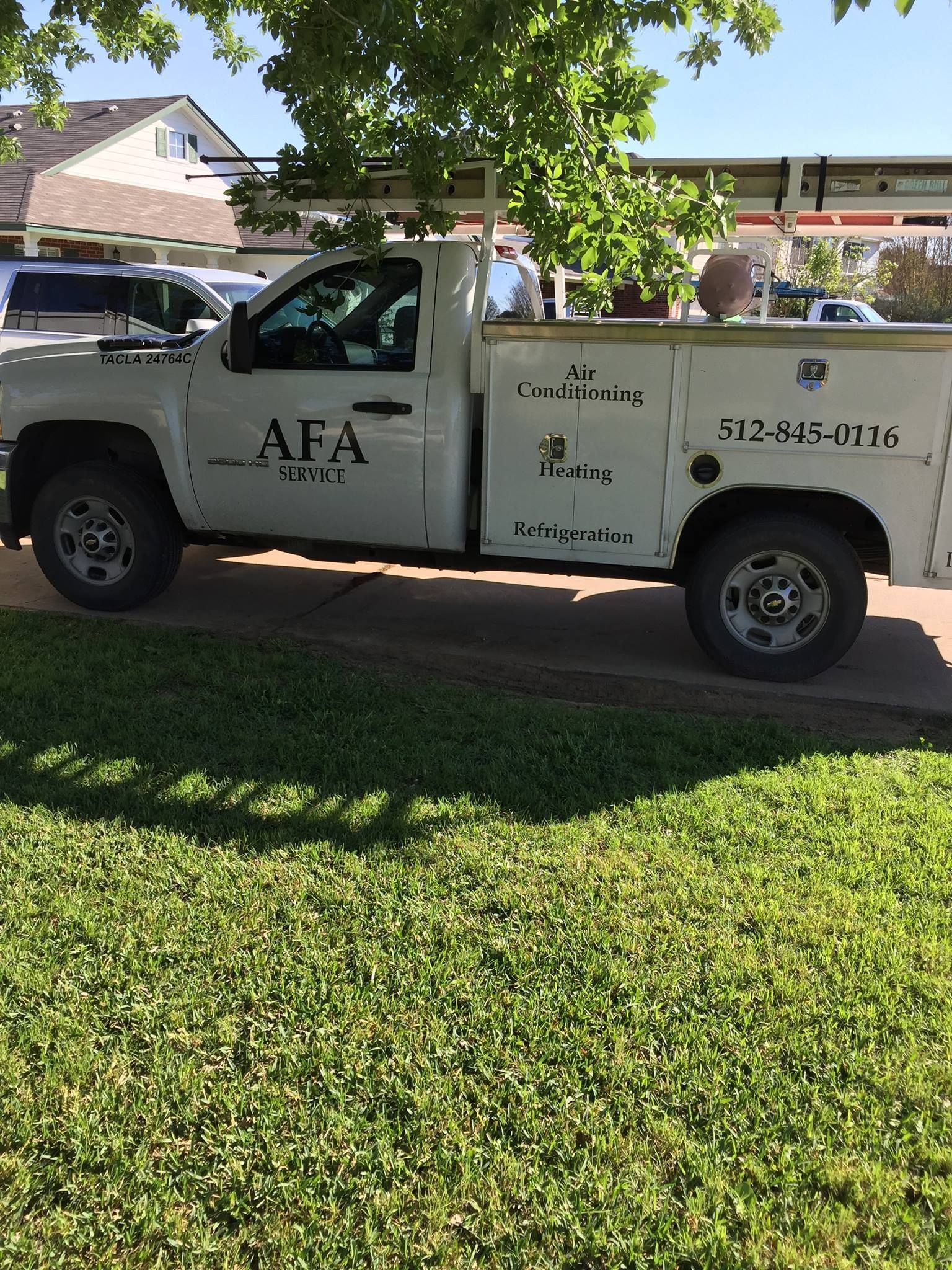 A white truck with the word afa on the side is parked in the grass from AFA Service